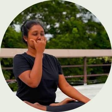 A woman seated in meditation, practising breath awareness outdoors